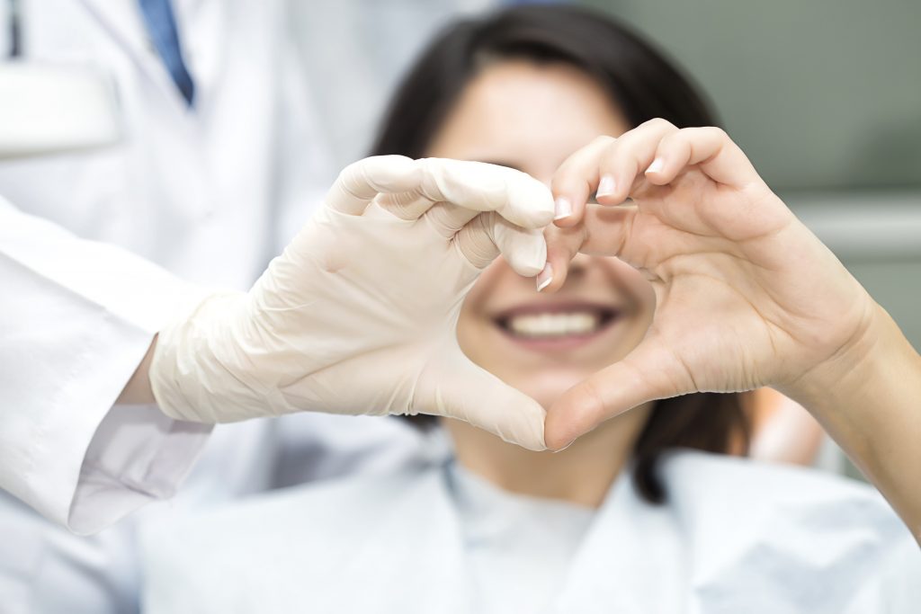 Woman holding her hands in a heart while smiling